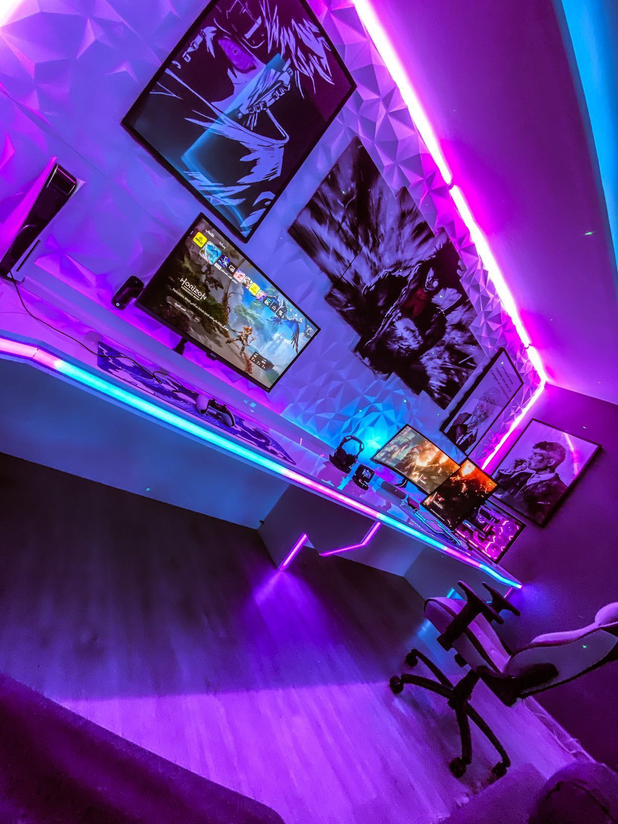 Gaming desk with pink and purple RGB lighting along the ceiling and desk edge