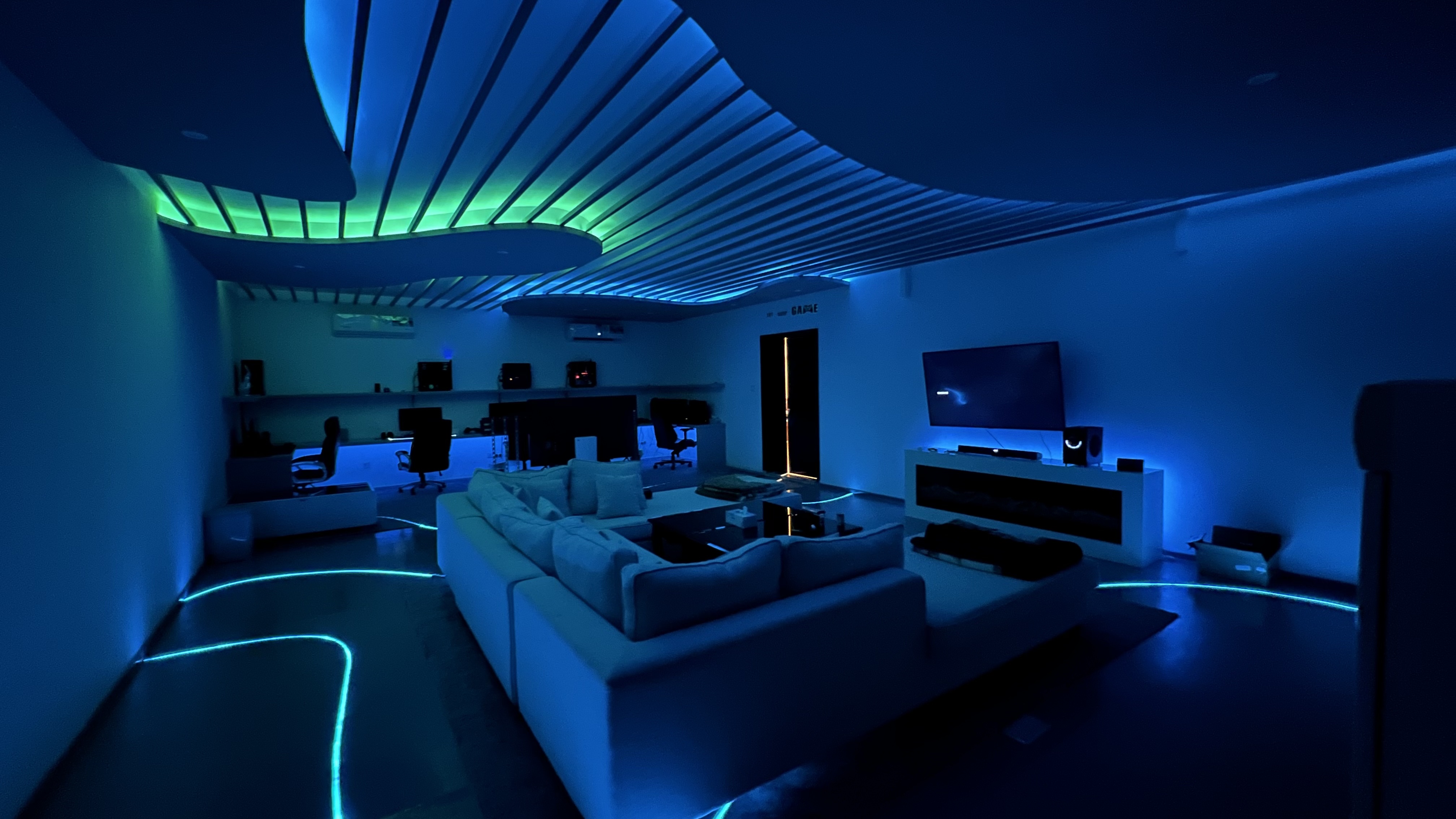 Living room cove lighting in blue and green with a floor LED line around the seating