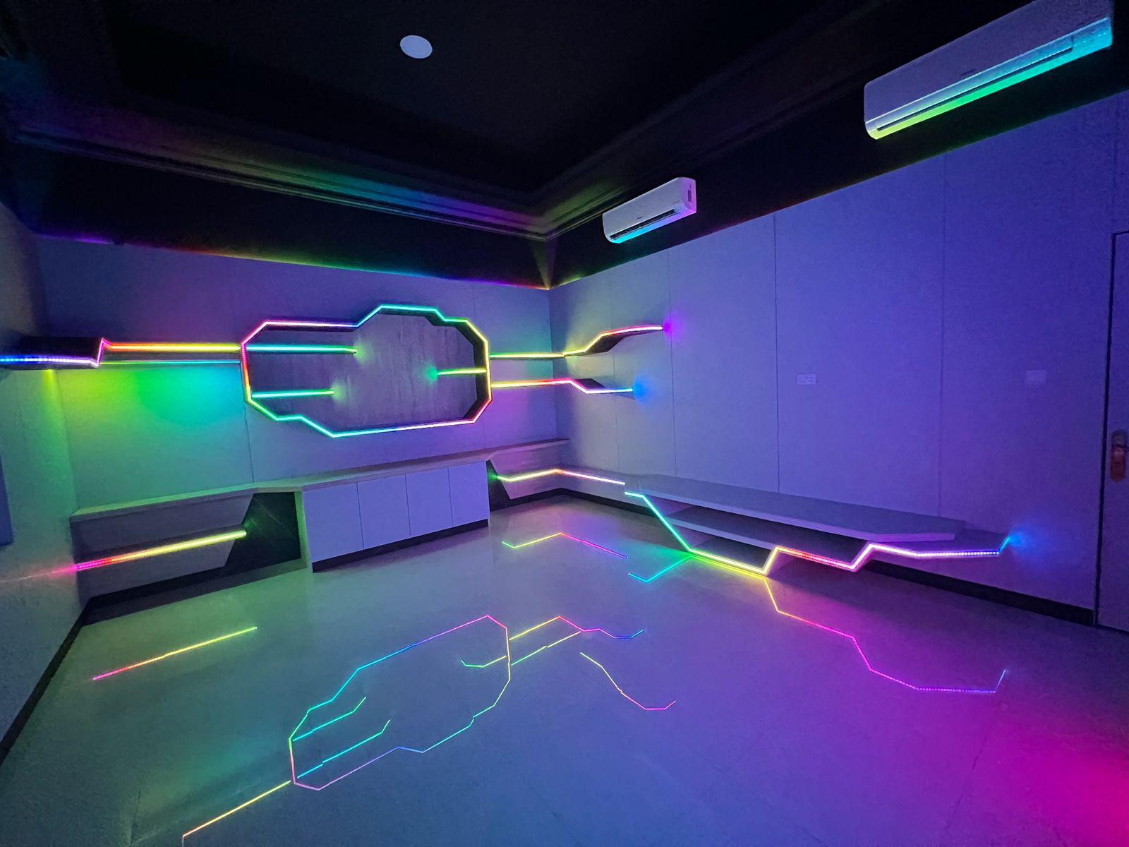 RGB geometric wall feature and floor lines in an entertainment room
